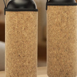 Two cork bottles with black lids and handles on a wooden surface.