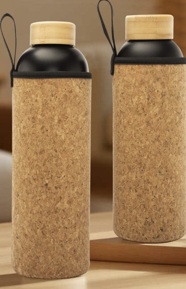 Two cork bottles with black lids and handles on a wooden surface.