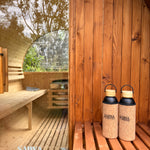 Two bottles with cork lids on a wooden  sauna.