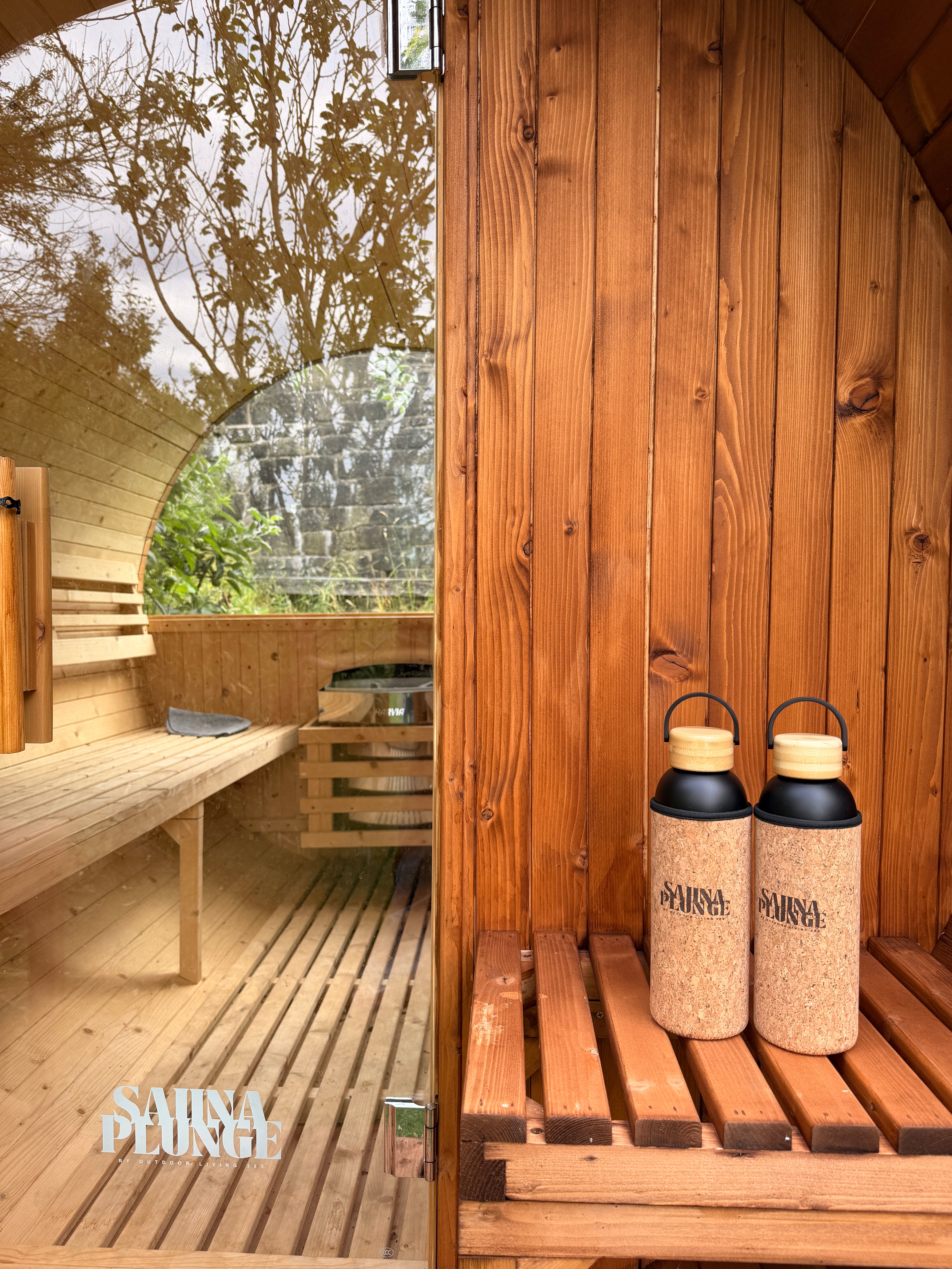 Two bottles with cork lids on a wooden  sauna.